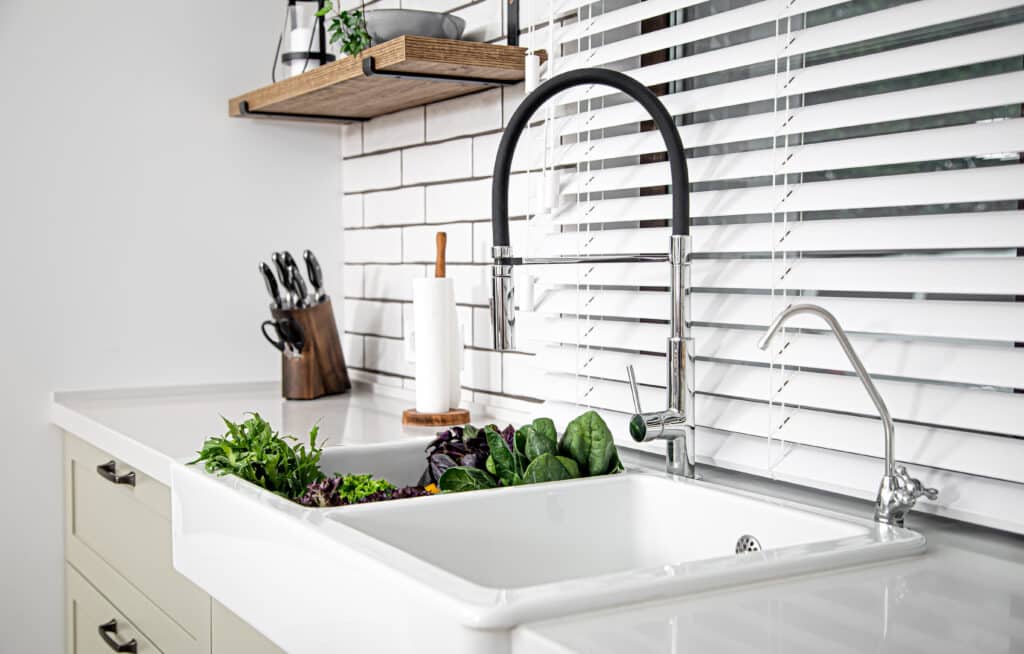 Wood shelf on tile backsplash over wood cabinets with a quartz countertop.