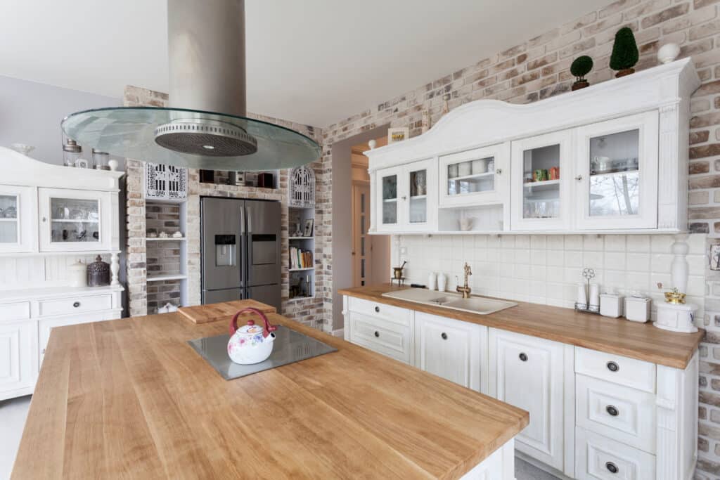 Natural wood countertops set against white kitchen cabinets